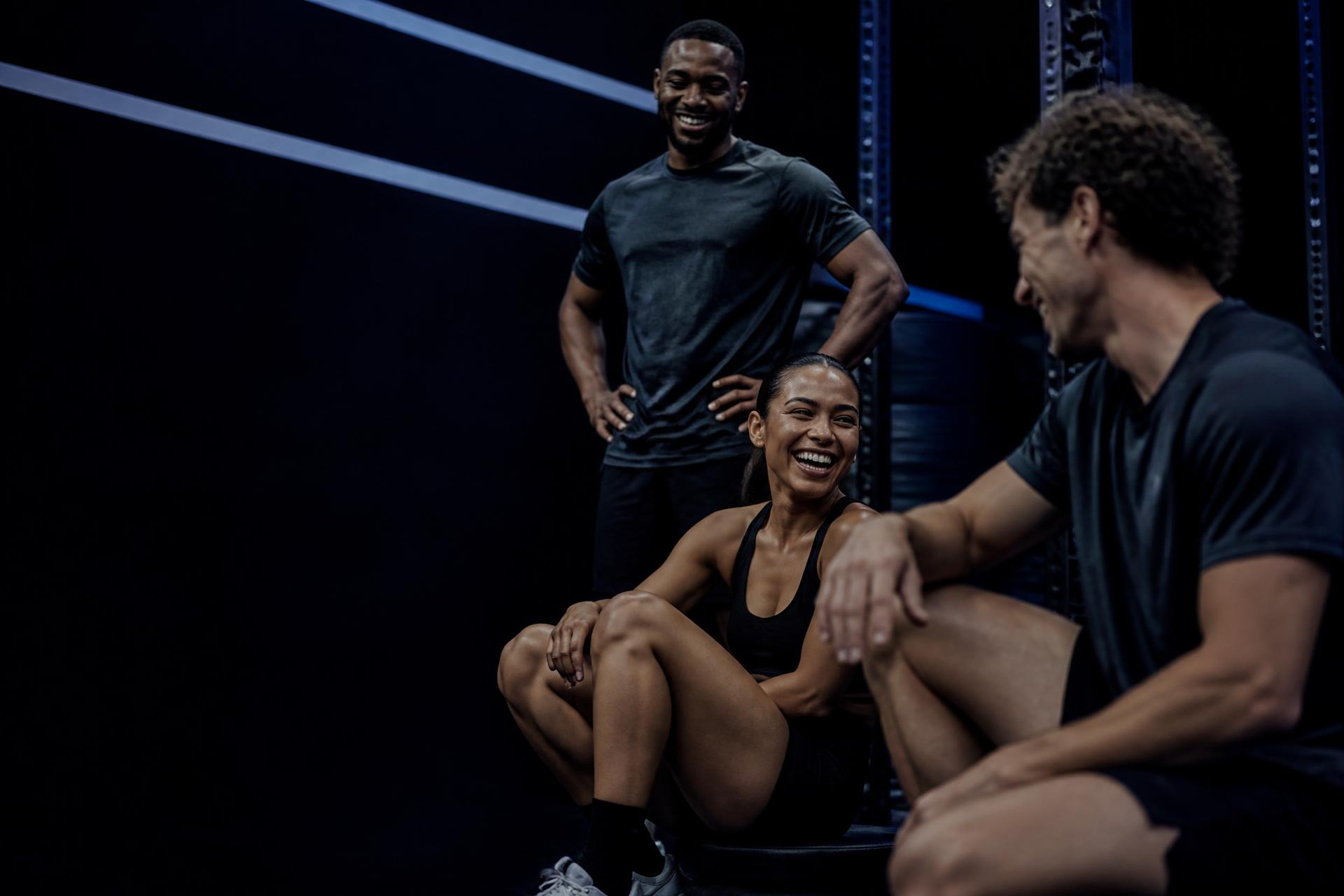 Friends training together in a dark gym